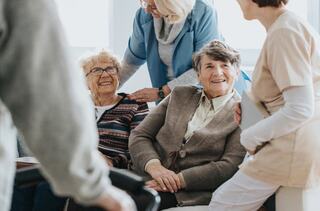 five individuals grouped closely together share a friendly smile