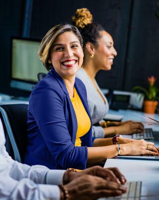 three people sitting in front of computers