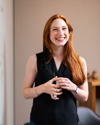 person standing holding a whiteboard marker