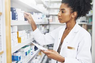 pharmacist using a tablet to help a customer